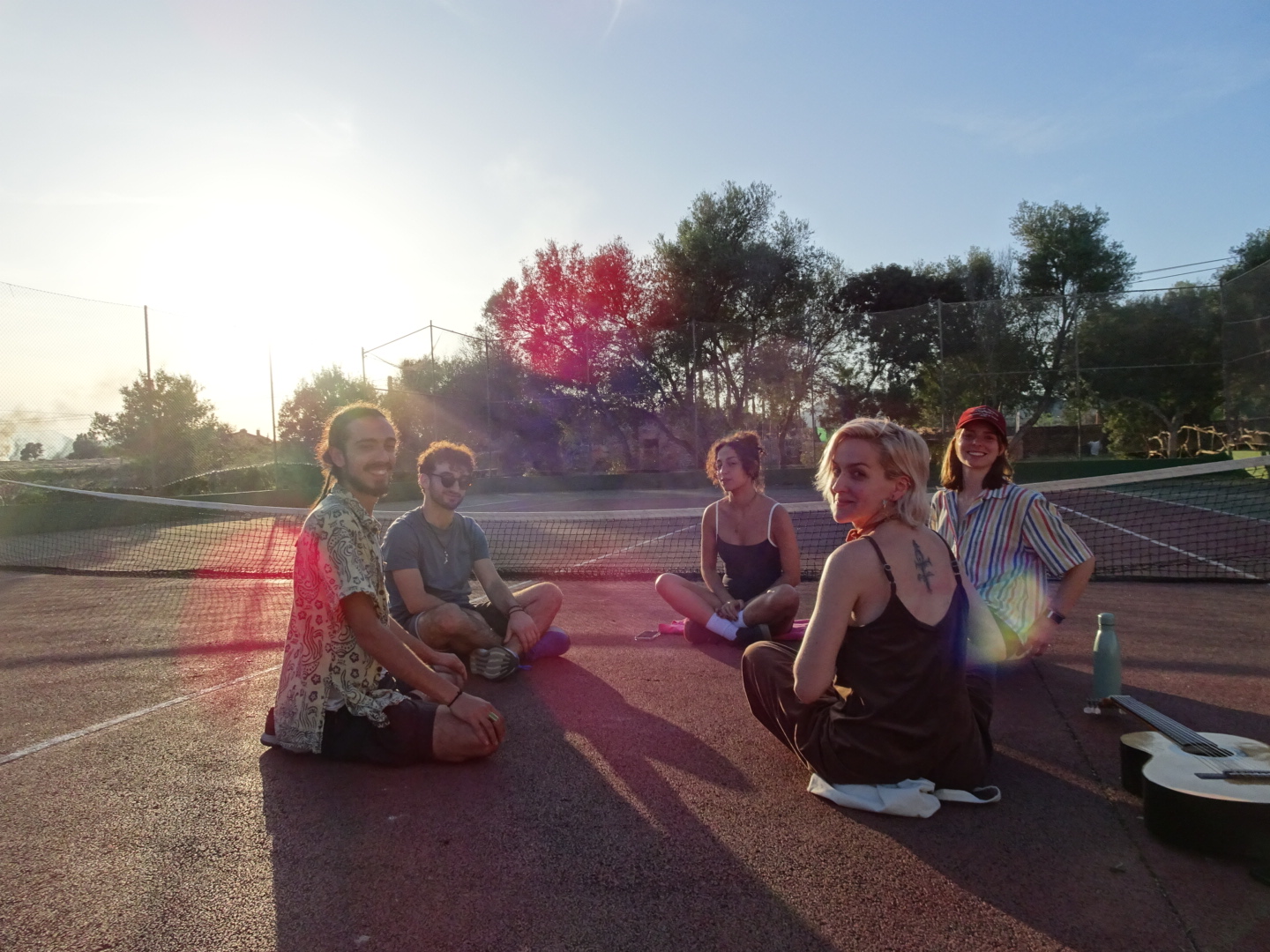 Grupo de Earth Explorers en la pista de tenis al atardecer